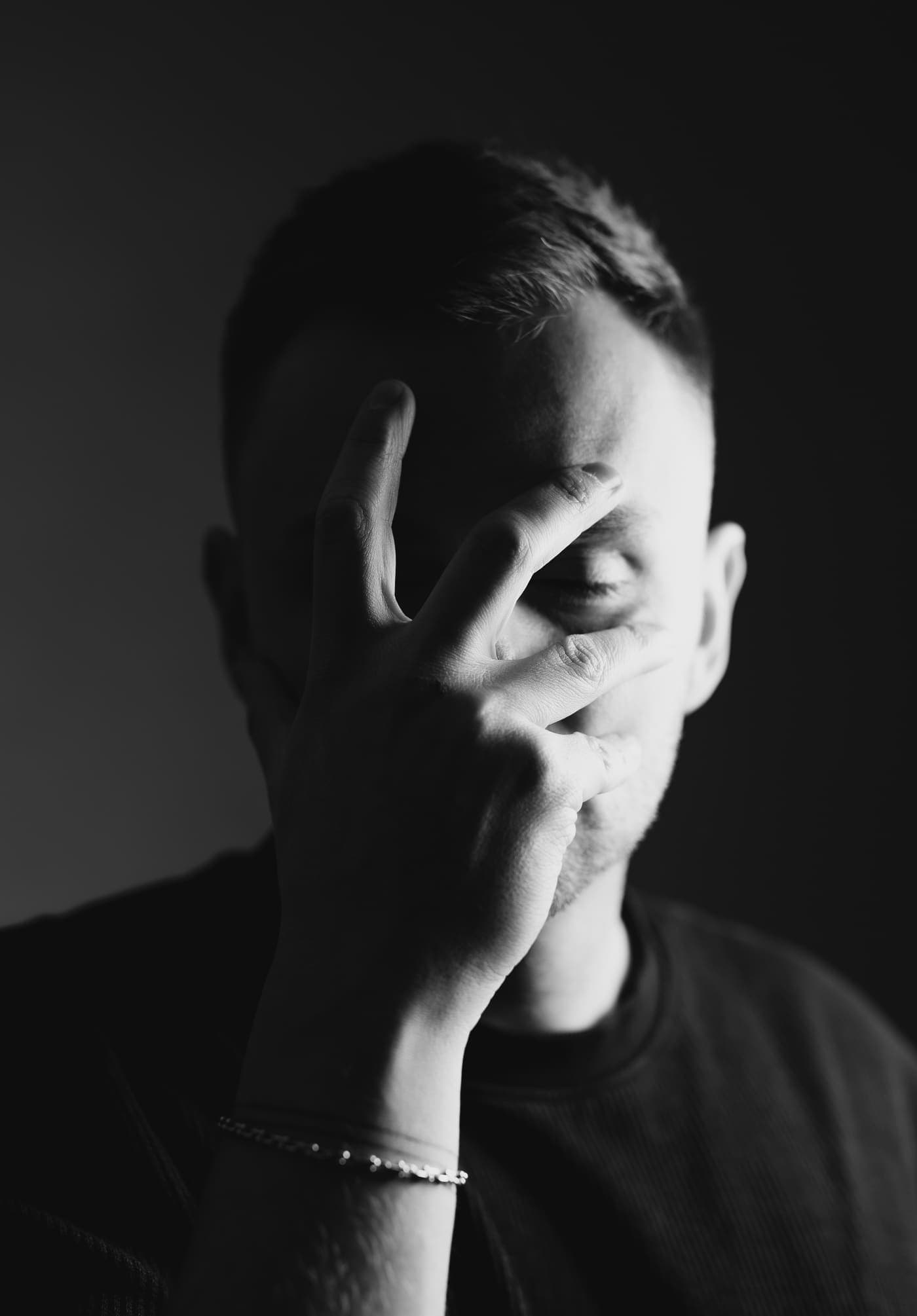 Low-key portrait of Goeran Meyer, one hand across his face