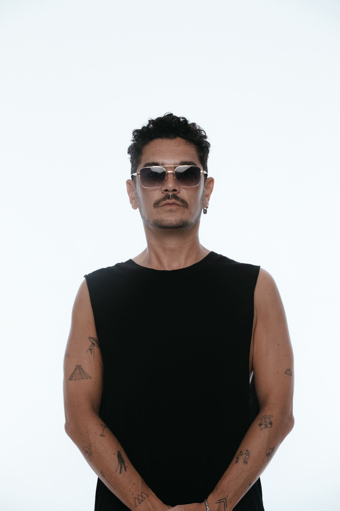 Kaiser Waldon in sunglasses and a black vest, full length on white