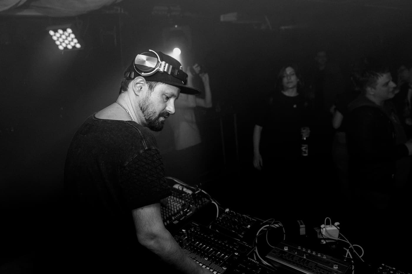 Oldrich Sic Jr. playing in a dark club booth, crowd behind him