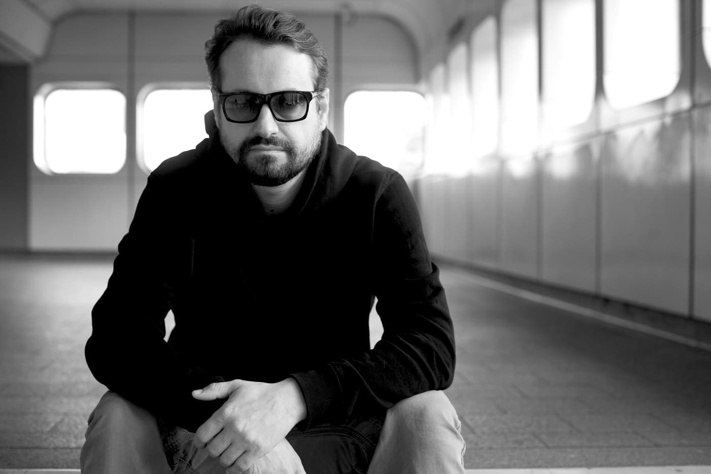 Oldrich Sic Jr. seated in a train carriage in sunglasses