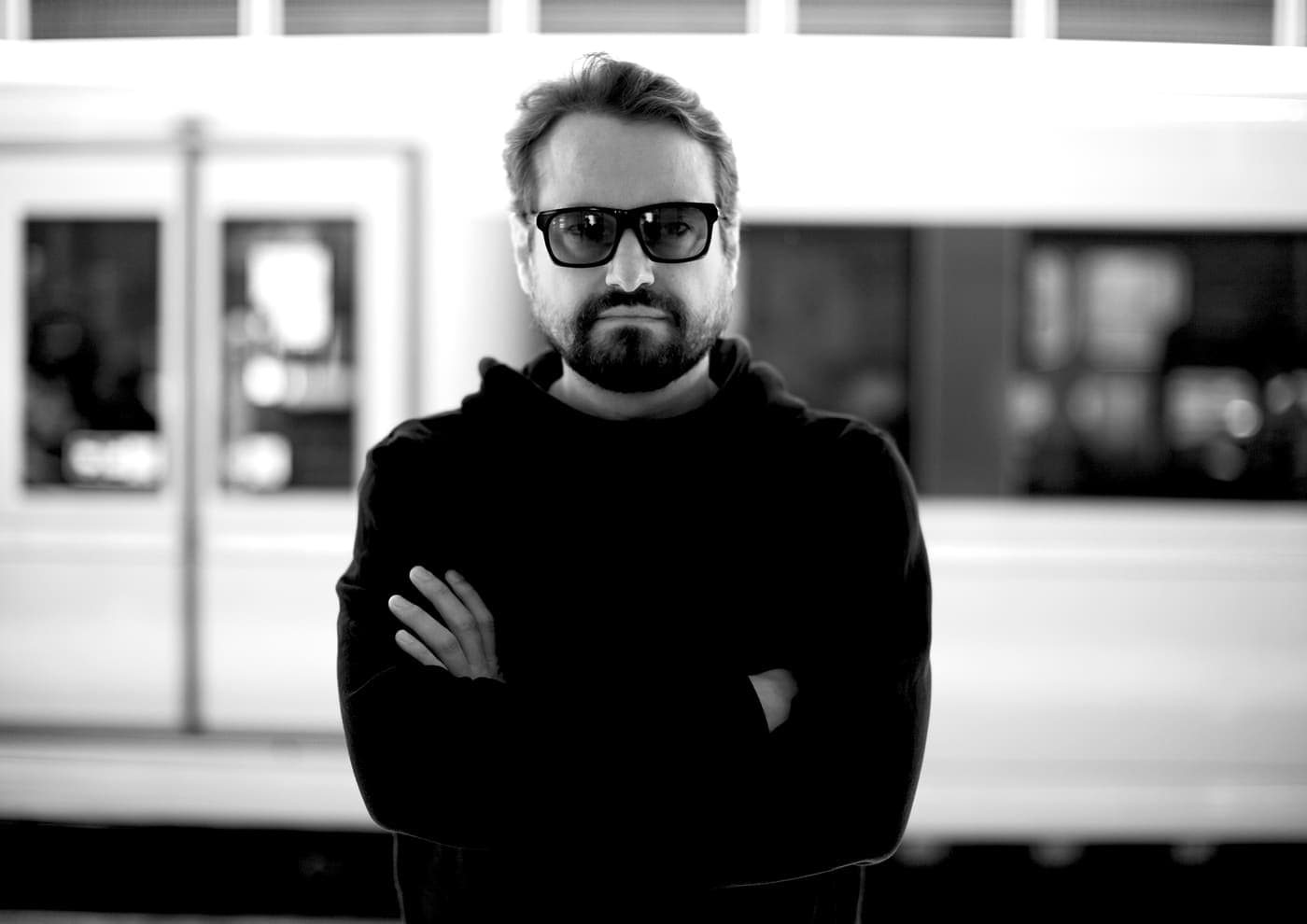 Oldrich Sic Jr. beside a passing train, arms crossed