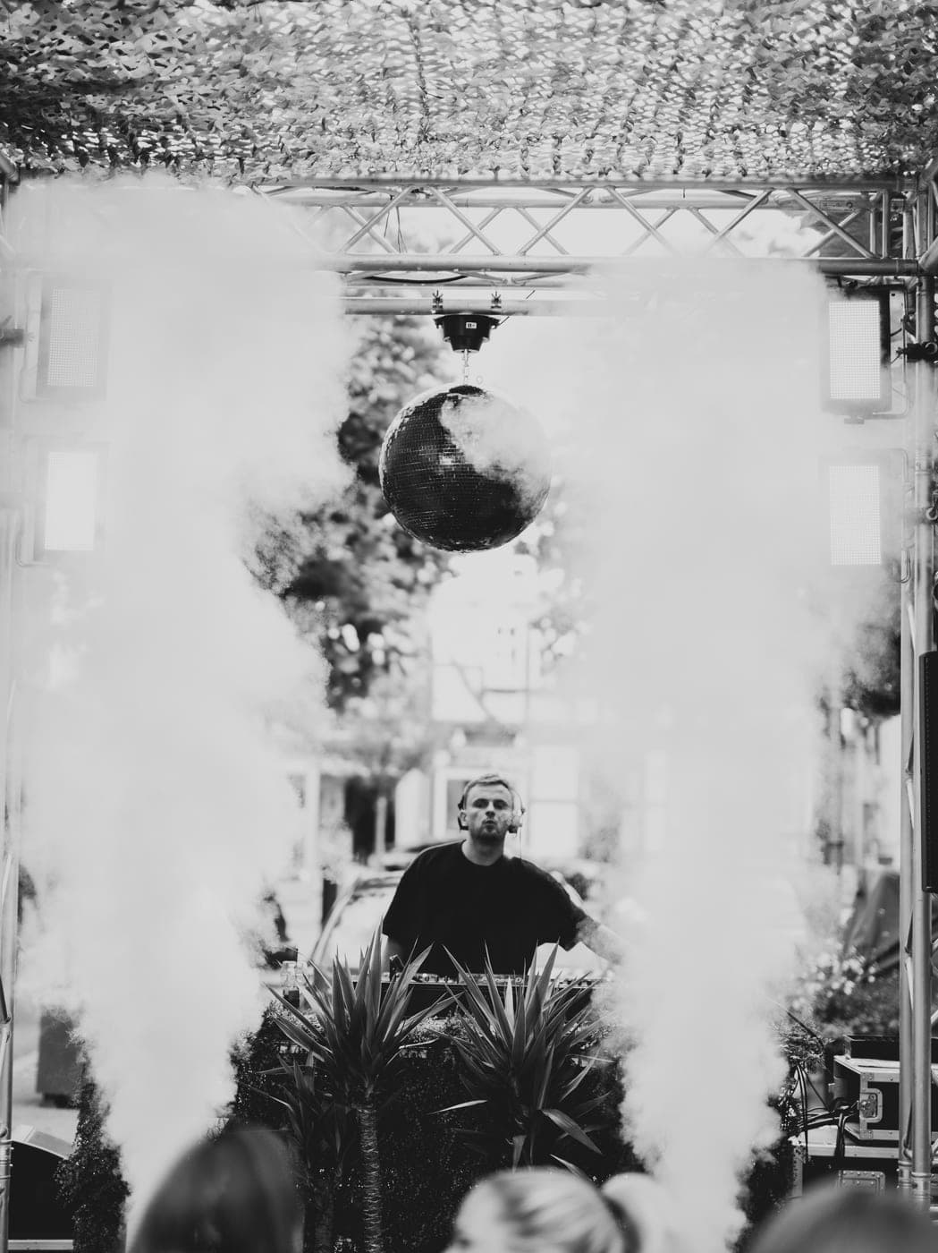 DJ unter der Discokugel im Nebel, Live-Gig Open-Air, Schwarz-Weiß