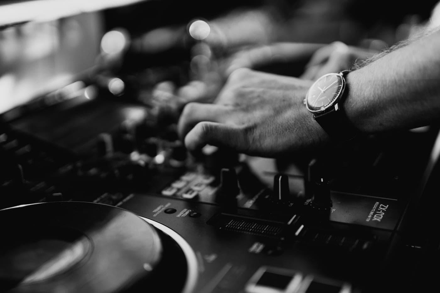Hand mit Armbanduhr am Pioneer-DJ-Mixer, Nahaufnahme
