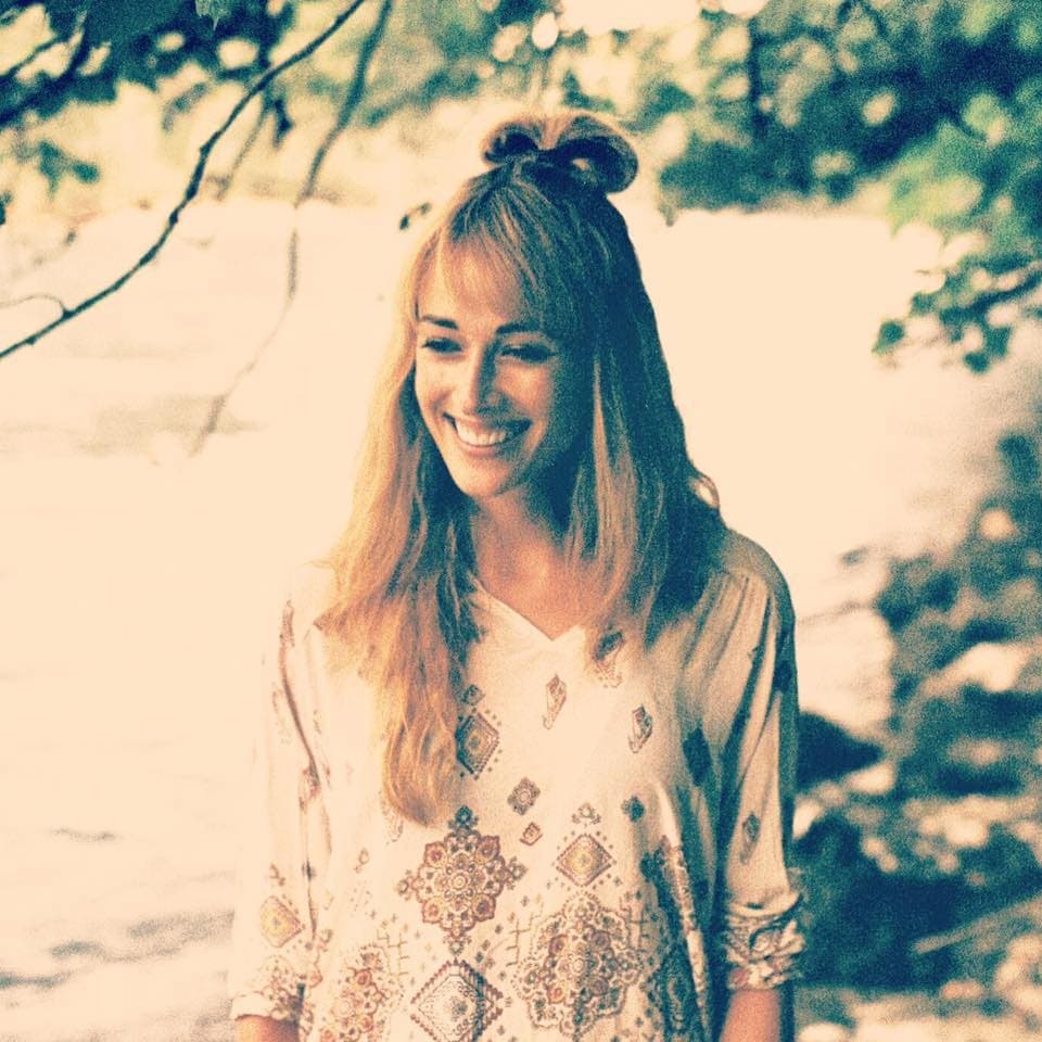 Juli Lee outdoors in daylight, smiling, hair tied up