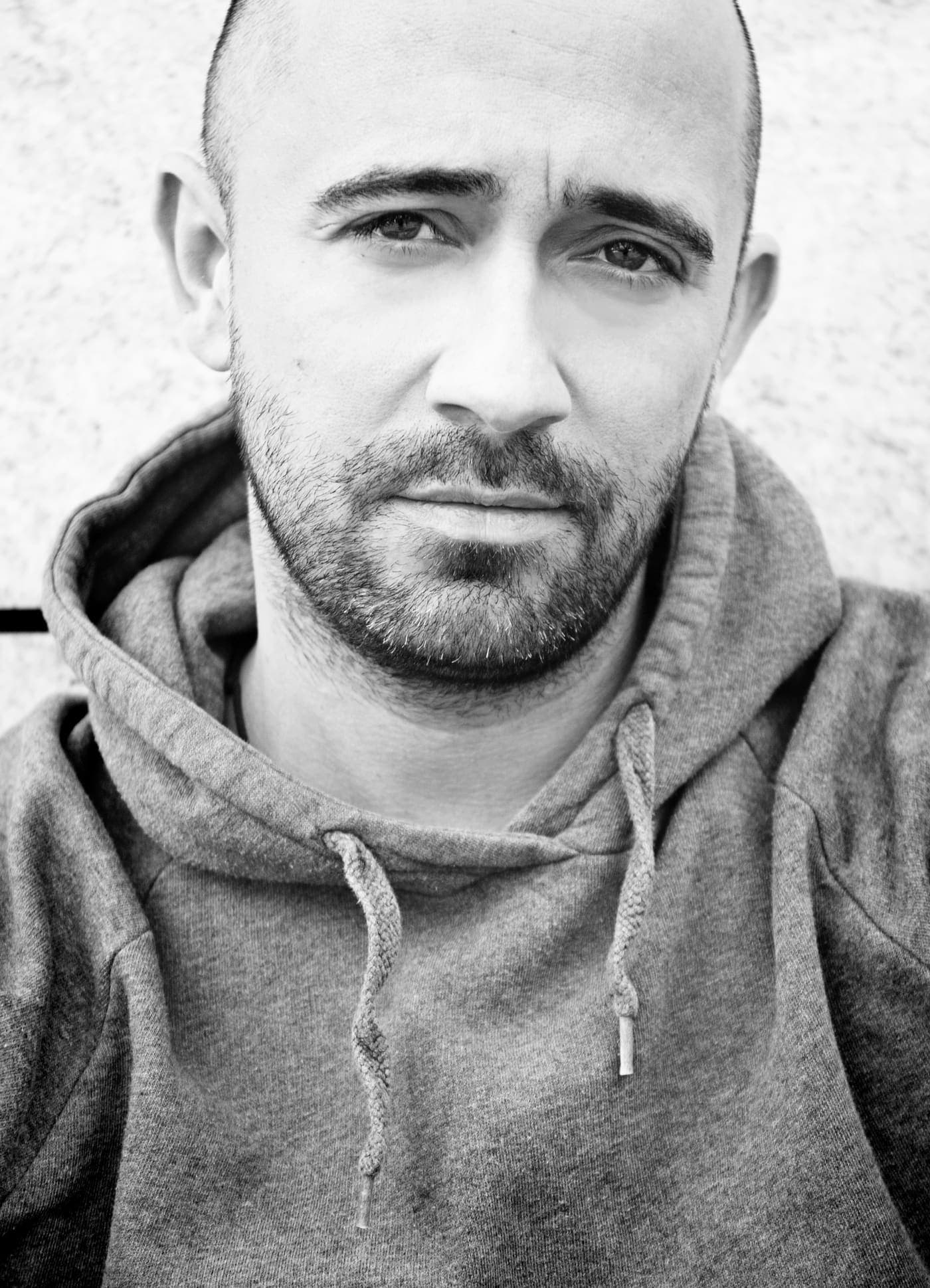 Black and white portrait of Manuel Rodriguez in a hooded sweatshirt