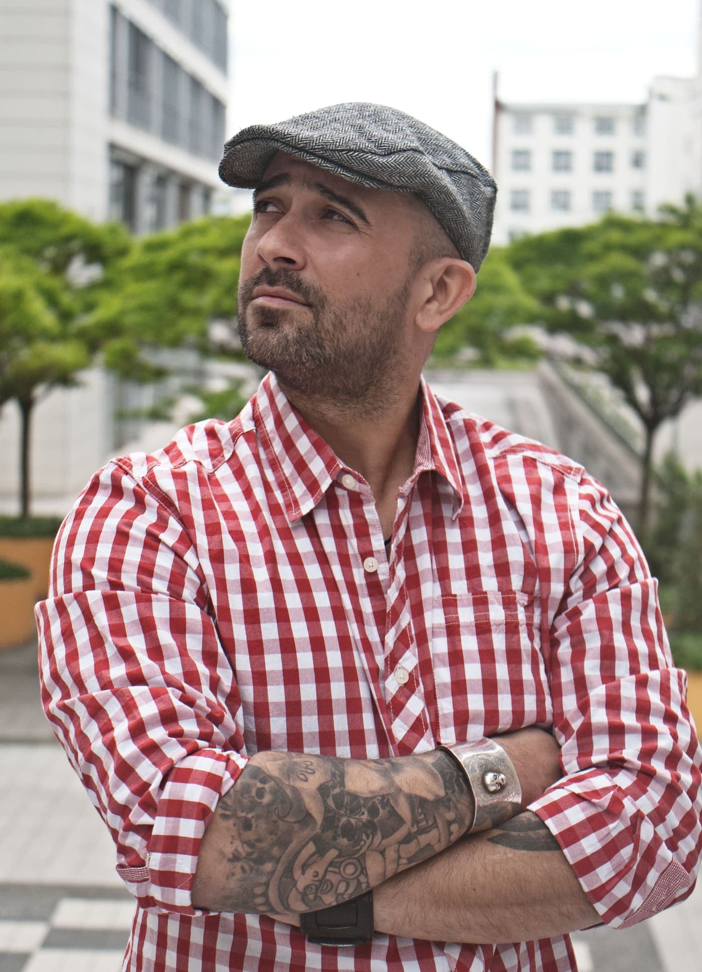 Manuel Rodriguez in a flat cap and checked shirt, arms crossed